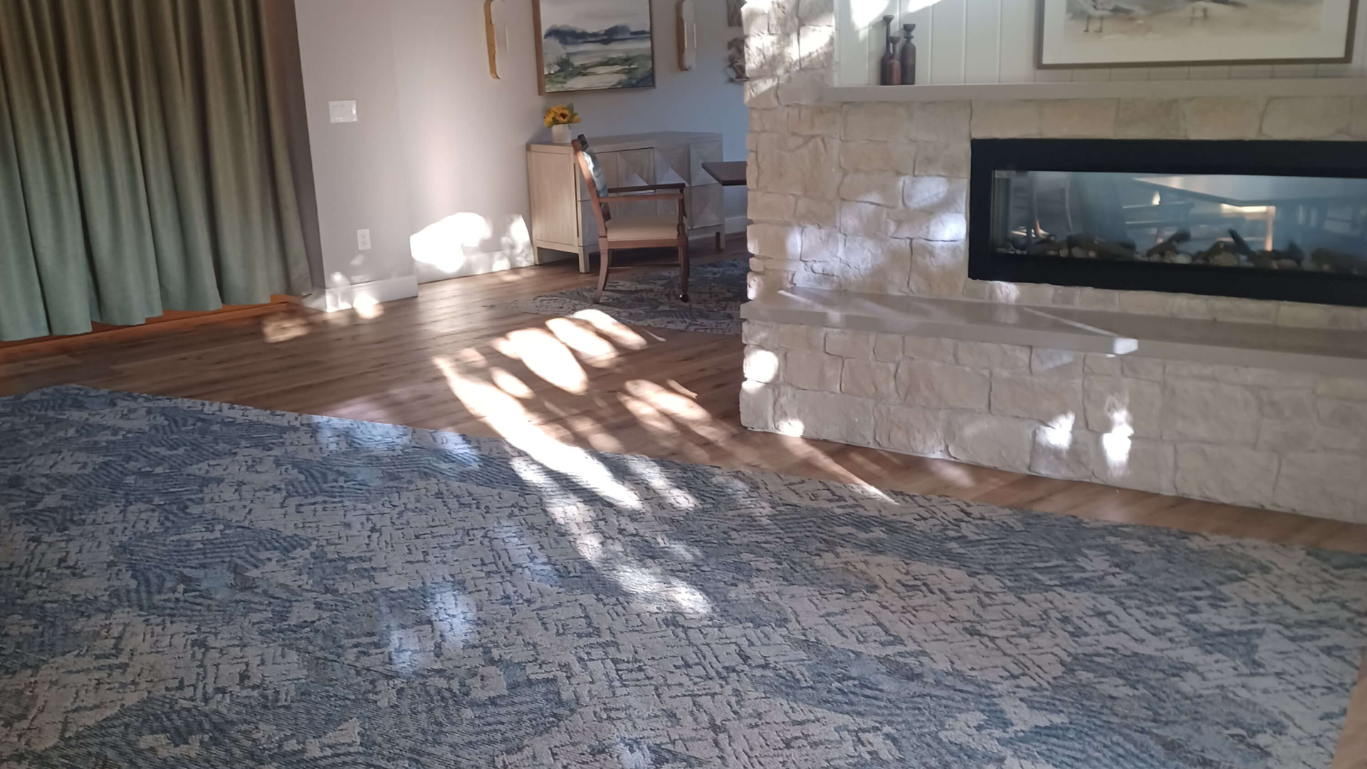 blue area rug in front of a fireplace